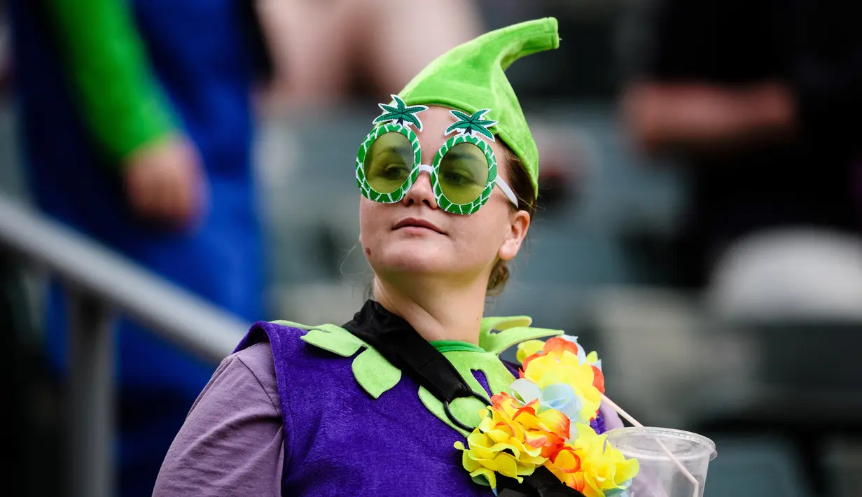 Seorang fans wanita mengenakan kostum unik saat menyaksikan pertandingan RugbY Sevens di Hong Kong (8/4). Para wanita yang  ini hadir mengenakan pakaian dan atribut unik demi mendukung tim kesayangannya. (AFP Photo / Anthony Wallace)