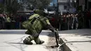Seorang anggota tim penjinak bom saat akan mengamankan sebuah benda mencurigakan dipinggir jalan kompleks kantor Singha Durbar, Nepal, (1/3).Setelah diselidiki benda itu hanyalah sebuah alarm biasa. (REUTERS / Navesh Chitrakar)
