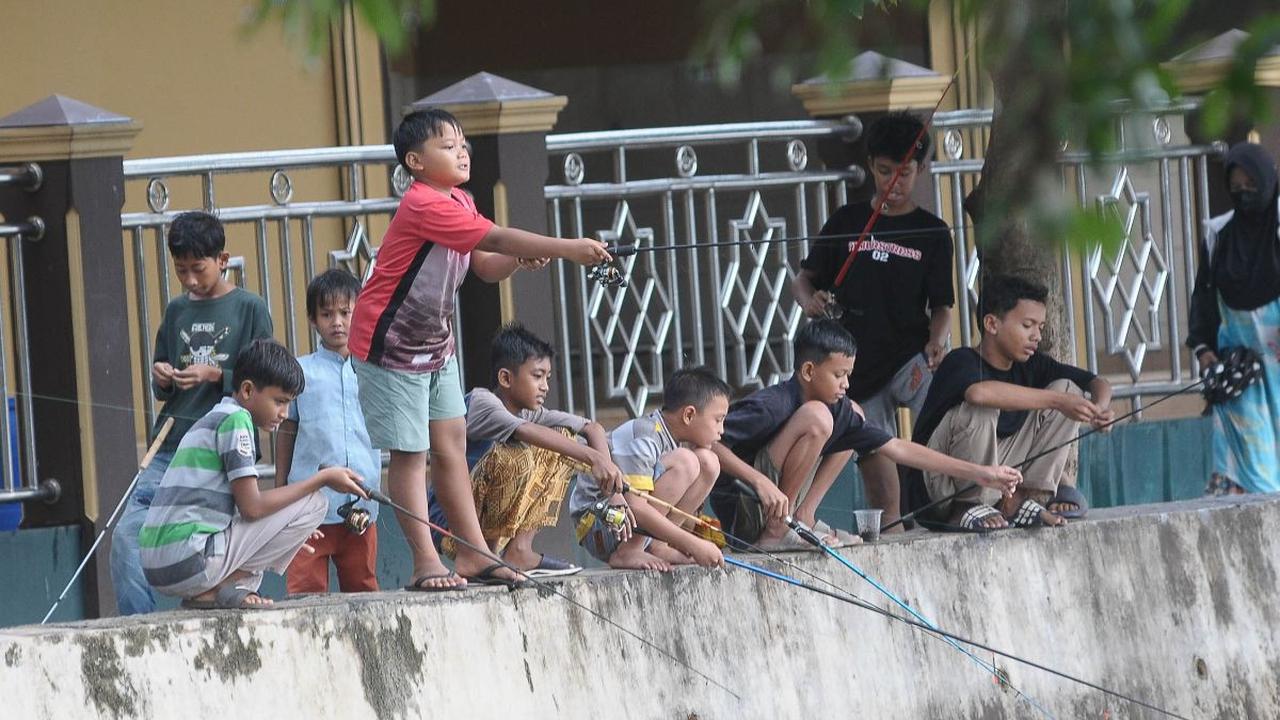 Sejumlah anak memancing ikan di Situ Cicadas, Jakarta, Sabtu (16/3/2024). Memasuki bulan suci Ramadan, situ yang berada di perbatasan Depok dan Jakarta Timur ini semakin ramai dengan kehadiran warga yang memancing ikan. Merdeka.com/Imam Buhori<br>