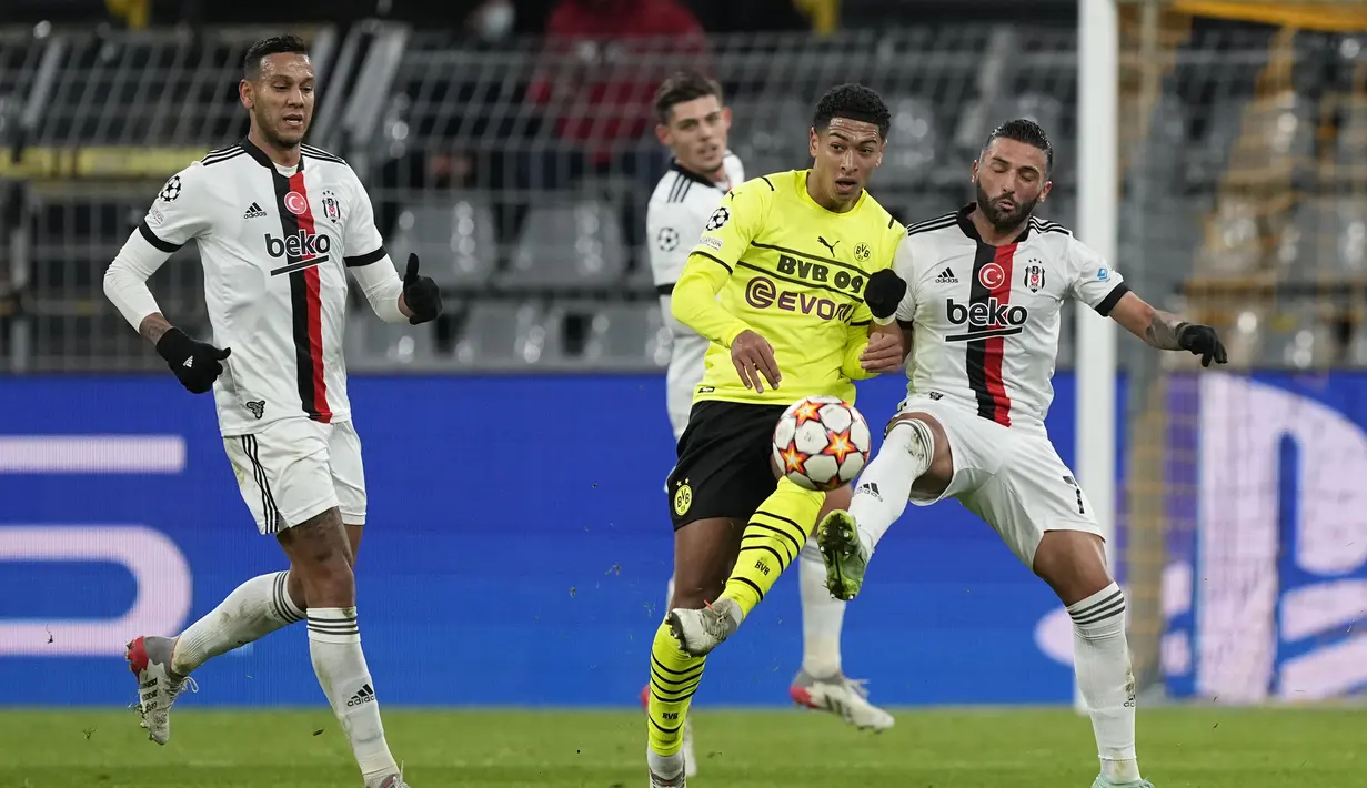 Pemain Dortmund Jude Bellingham berebut bola dengan pemain Besiktas Umut Meras pada pertandingan Grup C Liga Champions di Signal Iduna Park, Jerman, Rabu (8/12/2021). Dortmund menang telak atas Besiktas dengan skor 5-0. (AP Photo/ Martin Meissner)