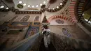 Pekerja mengenakan pakaian pelindung menyemprotkan disinfektan bagian dalam Masjid Suleymaniye yang bersejarah pada hari ketiga Idul Fitri di Istanbul, Selasa (26/5/2020). Beberapa masjid didisinfektan sebelum dibuka kembali pada 29 Mei usai ditutup selama lebih dari enam minggu. (AP/Emrah Gurel)