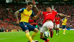 Bek Arsenal, Héctor Bellerín (kiri) berusaha mengumpan bola dari kejaran bek Marcos Rojo saat Laga Liga Premier Inggris di Stadion Old Trafford, Minggu (17/5/2015). Manchester United bermain imbang 1-1 atas Arsenal. (Reuters/Jason Cairnduff)