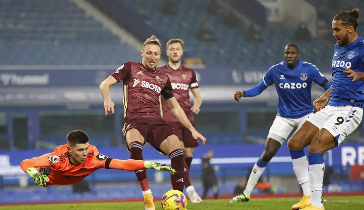 Kiper Leeds United, Illan Meslier (kiri), berusaha menjangkau bola dalam laga lanjutan Liga Inggris 2020/21 melawan Everton di Goodison Park Stadium, Sabtu (28/11/2020) waktu setempat. Leeds United menang 1-0 atas Everton. (AFP/Clive Brunskill/Pool)