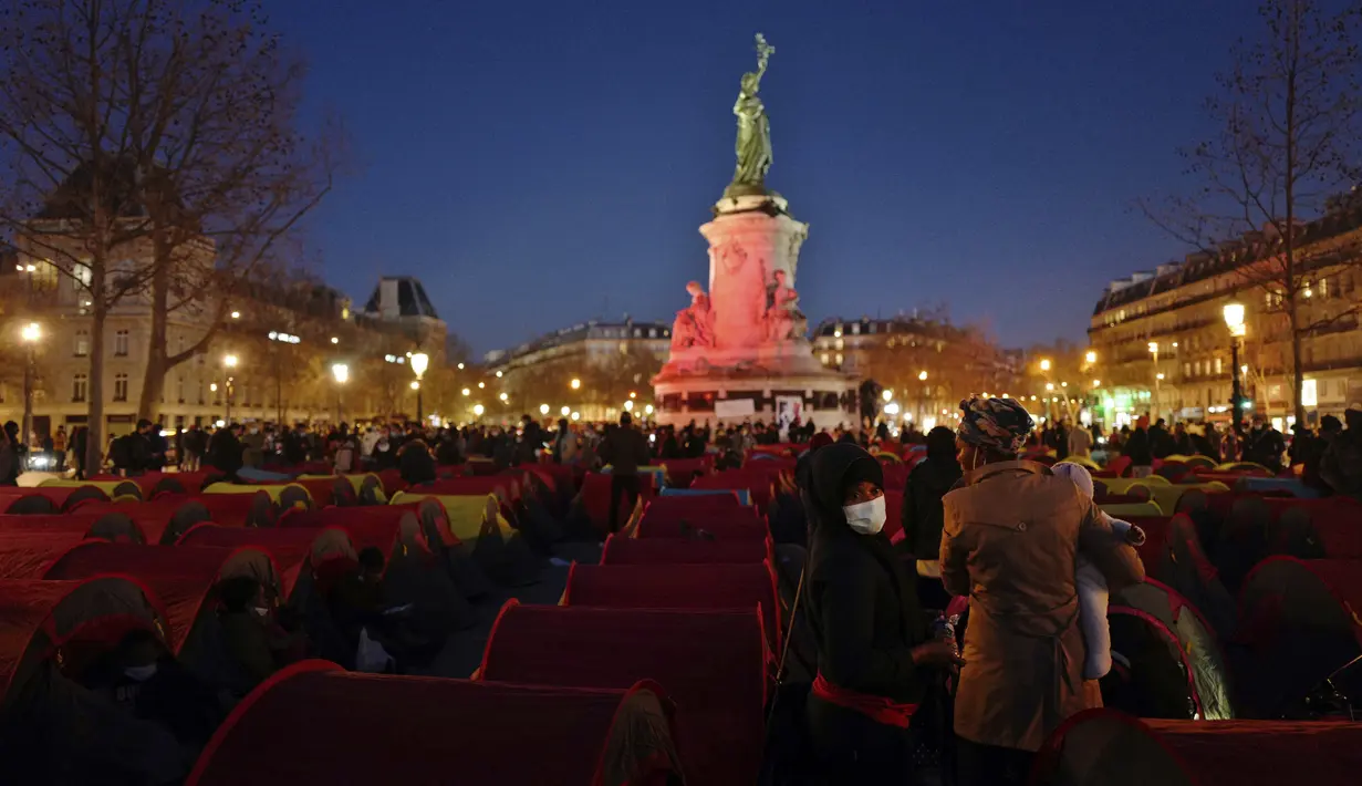 Para migran mendirikan tenda di Republic square, pusat kota Paris, pada Kamis (25/3/2021). Hampir 400 tenda didirikan di alun-aun tersebut untuk menarik perhatian atas kondisi kehidupan mereka dan menuntut akomodasi. (AP Photo/Rafael Yaghobzadeh)