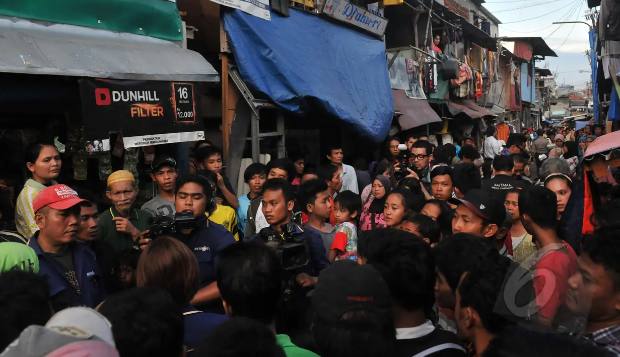 Puluhan warga berkumpul menyaksikan para pewarta melakukan pemberitaan di sekitar lokasi ledakan, jl Jati Bunder, Kebon Kacang, Jakarta Pusat, Rabu (8/4/2015). Akibat dari ledakan ini empat oaring dikabarkan terluka. (Liputan6.com/Johan Tallo)