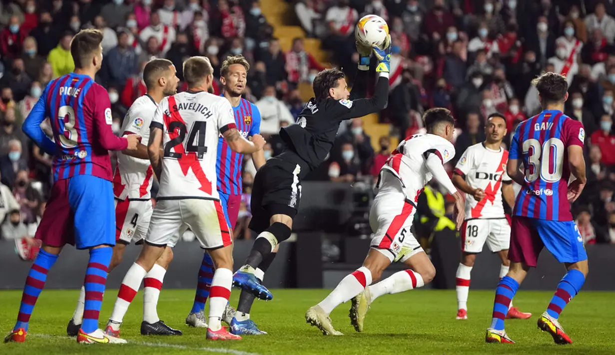 Penjaga gawang Rayo Vallecano Stole Dimitrievski (tengah) menangkap bola saat melawan Barcelona pada pertandingan La Liga Spanyol di Stadion Vallecas, Madrid, Spanyol, 27 Oktober 2021. Barcelona kalah 0-1. (AP Photo/Manu Fernandez)