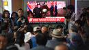 Calon penumpang dan awak media melihat berita pertemuan Presiden AS Donald Trump dan pemimpin Korea Utara Kim Jong-un di sebuah stasiun kereta api Seoul, Selasa (12/6). Untuk pertama kalinya dalam sejarah, Trump dan Kim bertemu. (AFP PHOTO/Jung Yeon-je)