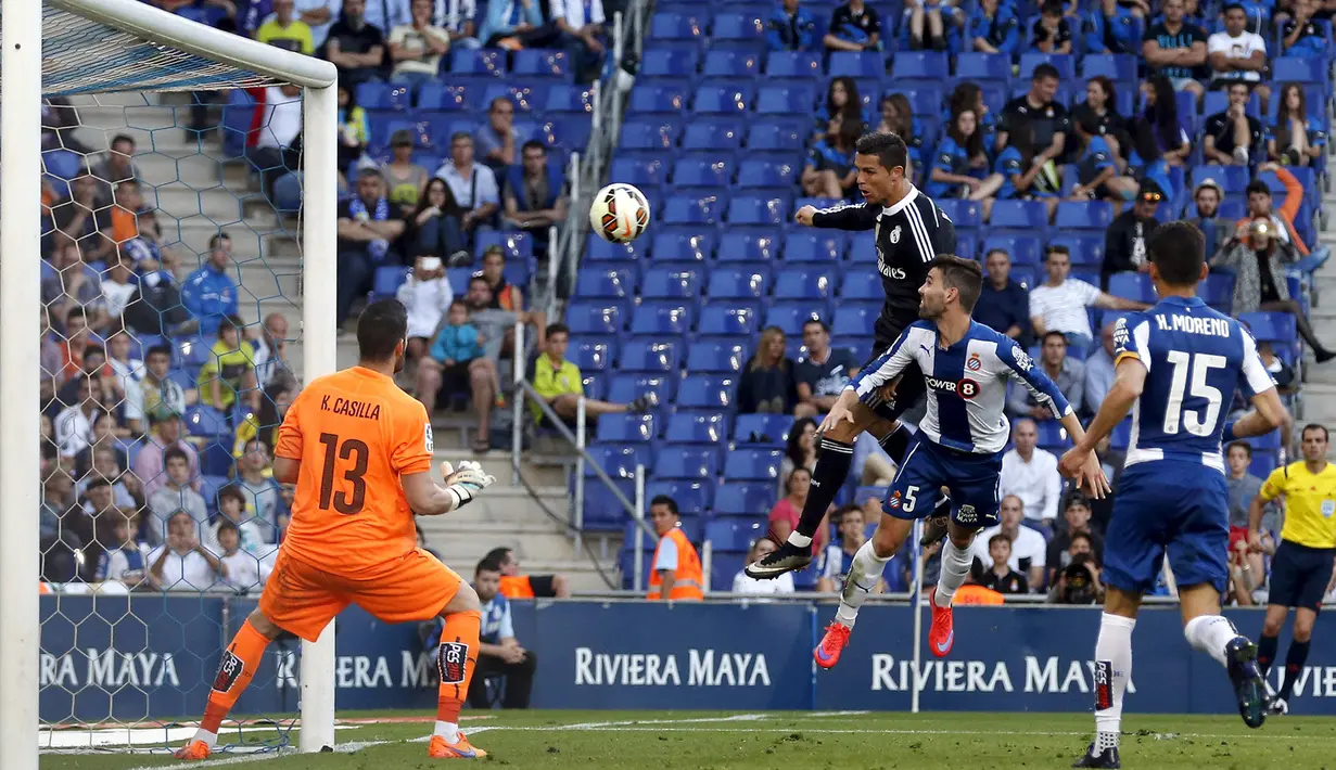Cristiano Ronaldo (tengah) menyudul bola ke arah kiper Espanyol Kike Casilla pada laga Liga Spanyol di Stadion Power8, Senin (18/5/2015). Real Madrid menang 4-1 atas Espanyol. (Reuters/Gustau Nacarino)