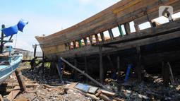 Kondisi kapal motor saat diperbaiki di Pelabuhan Kalibaru, Jakarta, Rabu (8/3/2023). Butuh waktu sekitar dua bulan untuk memperbaiki satu unit perahu kayu, tergantung tingkat kesulitan perbaikan. (merdeka.com/Imam Buhori)