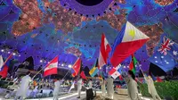 Para pembawa bendera untuk negara-negara peserta masuk selama upacara pembukaan Dubai Expo 2020 di Dubai, Uni Emirat Arab, 30 September 2021. Pembukaan Dubai Expo 2020 berlangsung mewah dengan menampilkan kembang api dan pertunjukan lampu untuk merayu dunia meski pandemi. (GIUSEPPE CACACE/AFP)