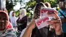 Petugas Disdukcapil membagikan Kartu Identitas Anak (KIA) di Pondok Aren, Tangerang Selatan, Jumat (16/11). Penerbitan KIA bertujuan untuk meningkatkan pendataan, perlindungan dan pelayanan publik. (Liputan6.com/Fery Pradolo)