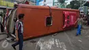 Warga berjalan di dekat bangkai bus Trans Semarang yang menabrak pangkalan ojek di Jalan Sultan Agung, Semarang, Minggu (17/7). Bus bernomor polisi H 1738 FG itu juga menabrak sebuah mobil Honda Brio dan sejumlah motor milik pengojek (Liputan6.com/Gholib)