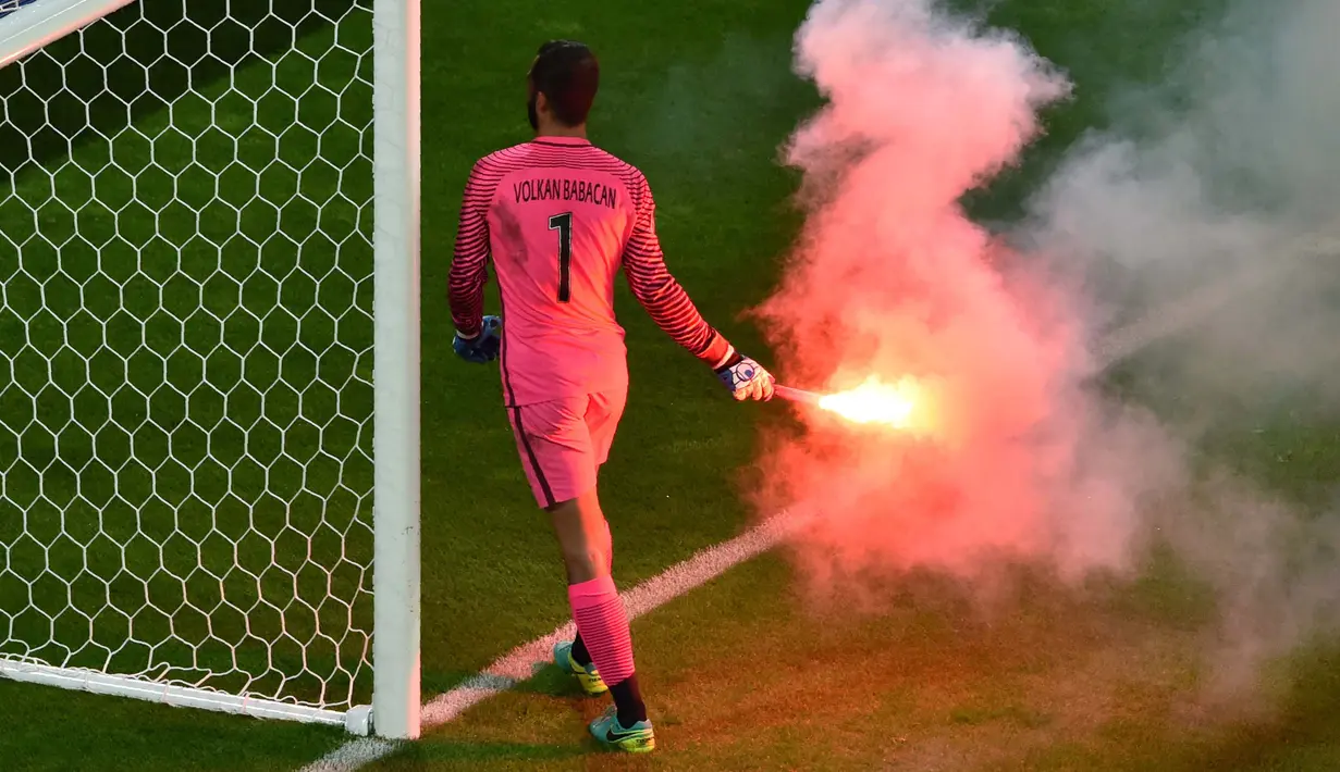 Kiper Turki, Volkan Babacan membuang flare yang dilempar suporter saat laga grup D Euro Cup 2016  antara Turki vs Republik Ceska di Stadion Bollaert-Delelis, Lens (22/6/2016) dini hari WIB. (AFP/Philippe Huguen)
