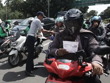 Petugas Dishub DKI Jakarta melakukan sosialisasi lajur khusus sepeda motor di Jalan MH Thamrin, Jakarta, Senin (29/1). (Liputan6.com/Arya Manggala)