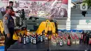 Petugas dengan alat berat menghancurkan botol minuman keras (miras) saat pemusnahan Miras dan barang bukti narkotika di Mapolrestabes Semarang, Jumat (20/12/2019). Pemusnahan barang bukti narkoba berupa sabu, inex dan pil koplo serta 5450 botol dan 140 liter ciu. (Liputan6.com/Gholib)