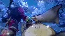 Santa Claus memberikan makanan kepada kumpulan ikan di aquarium besar Sea World, Taman Impian Jaya Ancol, Jakarta, Minggu (25/12). Sea World Indonesia memanjakan pengunjung yang berlibur dengan berbagai atraksi. (Liputan6.com/Faizal Fanani)