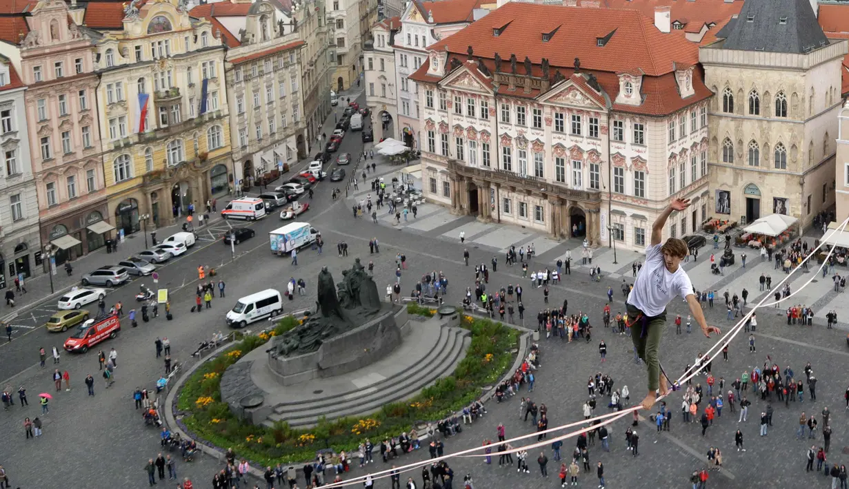 Atlet menyeimbangkan tubuhnya saat berjalan di atas tali yang membentang di Old Town Square, Praha, Republik Ceko, (25/9). Pertunjukan tersebut merupakan bagian kampanye dukungan orang-orang yang hidup dengan diabetes. (AP Photo/Petr David Josek)