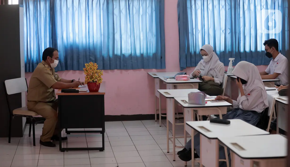 Guru mengajar saat uji coba pembelajaran tatap muka (PTM) terbatas di SMAN 1 Kota Tangerang, Banten, Senin (6/9/2021). Dinas Pendidikan Provinsi Banten uji coba PTM di SMA di Kota Tangerang secara terbatas dengan sistem bergiliran dan menerapkan protokol kesehatan ketat. (Liputan6.com/Angga Yuniar)