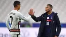 Striker Portugal, Cristiano Ronaldo, berbincang dengan striker Prancis, Kylian Mbappe, usai laga UEFA Nations League di Stadion Stade de France, Senin (12/10/2020). Kedua tim bermain imbang 0-0. (AFP/Franck Fife)