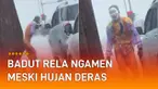 Meski di tengah hujan deras, ia tetap berjoget dan mengamen di persimpangan.