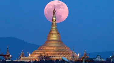 Penampakan fenomena supermoon dari balik pagoda Uppatasanti di langit Naypyitaw, Myanmar, Minggu (3/12). Supermoon adalah istilah populer untuk menyebut purnama yang posisi orbit Bulan sedang berada di jarak terdekat dengan Bumi. (AP/Aung Shine Oo)