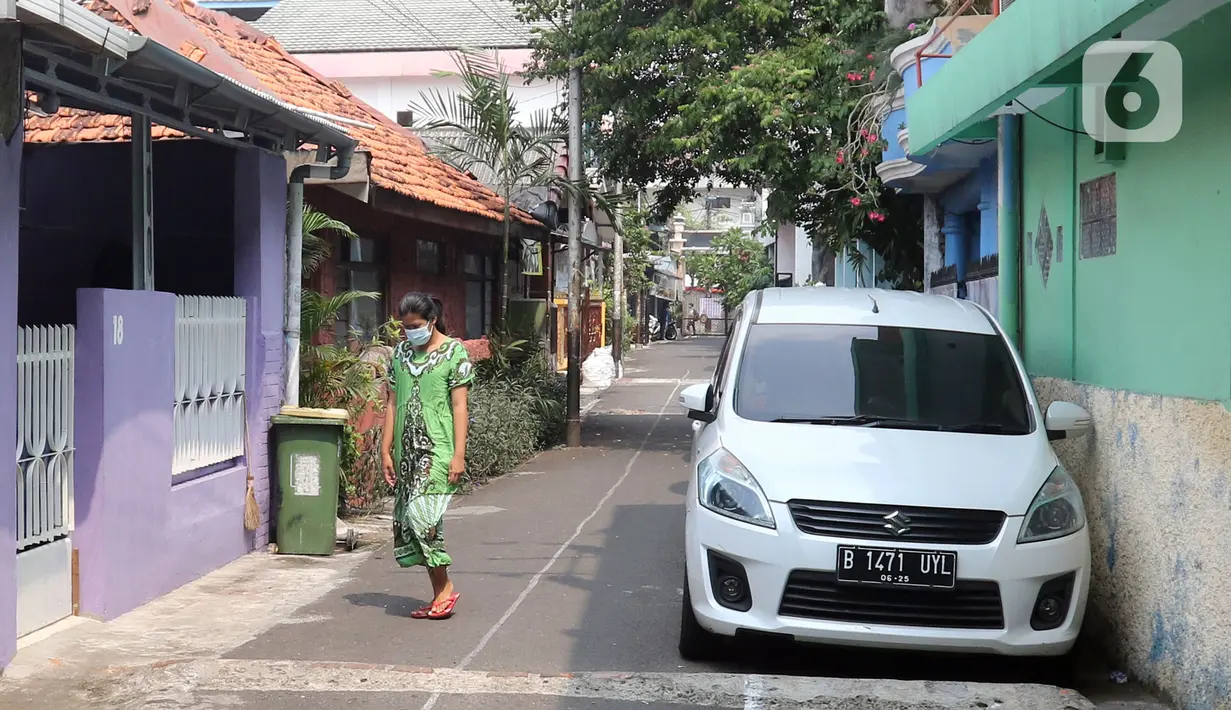 Seorang wanita berjalan di kawasan Intan Berduri, Sumur Batu, Jakarta, Rabu (9/06/2021). Kelurahan Sumur Batu memberlakukan mikro lockdown di RT 1, RT 2 dan RT di RW 03 setelah 34 warga positif COVID-19. (Liputan6.com/Herman Zakharia)