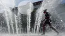 Seorang gadis bermain mendinginkan diri denggan di sebuah fontaine saat gelombang panas menerjang Eropa di Berlin, Jerman, Rabu (24/7/2019 ). Organisasi Meteorologi Dunia (WMO) menyatakan gelombang panas menegaskan dampak dari perubahan iklim. (AP Photo/Michael Sohn)