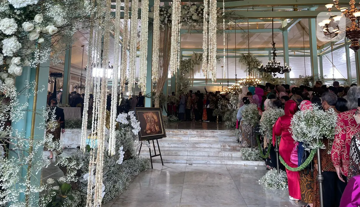 Sejumlah warga mengantre untuk bersalaman dengan putra bungsu Presiden Joko Widodo, Kaesang Pangarep dan istrinya Erina Gudono pada acara Ngunduh Mantu pernikahan di Pura Mangkunegaran, Solo, Minggu (11/12/2022). Antrean tamu undangan yang ingin berfoto dengan Kaesang Pangarep dan Erina Gudono beserta keluarga mengular panjang bahkan rela berdesak-desakan demi bisa berfoto dengan kedua mempelai. (Liputan6.com/Herman Zakharia)