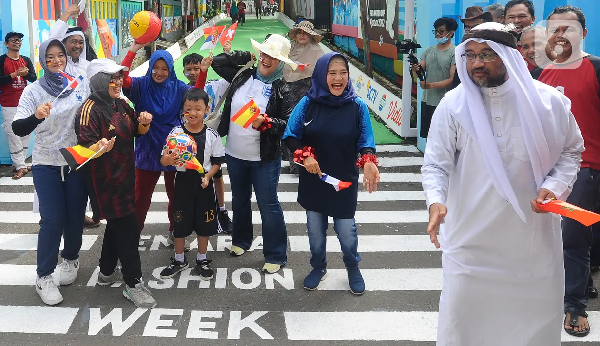 Warga dengan mengenakan jersey atau kostum tim sepak bola peserta Piala Dunia 2022 Qatar menggelar fashion show di Perum Depok Maharaja Blok M1 Cluster Cemara, Rangkapan Jaya, Depok, Minggu (20/11/2022).  (merdeka.com/Arie Basuki)