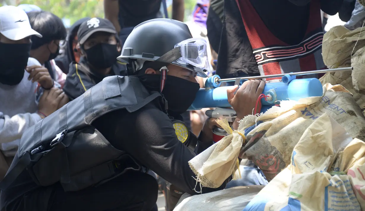 Pengunjuk menyiapkan senapan angin darurat untuk menghadapi polisi di kota Thaketa Yangon, Myanmar (27/3/2021). Para pengunjuk rasa menandai Hari Angkatan Bersenjata dengan menyerukan demonstrasi yang lebih besar. (AP Photo)