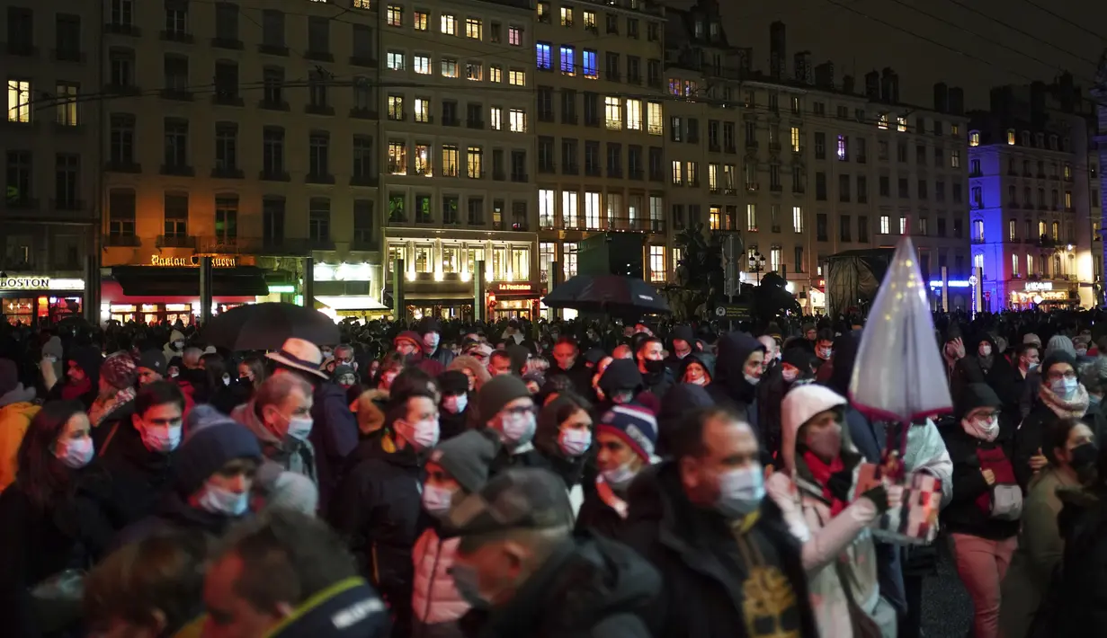 Orang-orang menghadiri pertunjukan cahaya malam di Lyon, Prancis tengah, Rabu (8/12/2021). Jutaan orang diperkirakan akan menghadiri acara Festival of Lights selama empat hari di kota itu. (AP Photo/Laurent Cipriani)