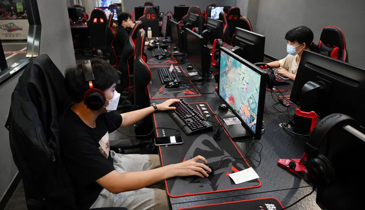 <p>Sejumlah orang bermain game komputer di sebuah kafe internet di Beijing, China, Jumat (10/9/2021). China kini membatasi waktu bermain game online bagi anak-anak dan remaja yang mulai berlaku minggu ini. (GREG BAKER/AFP)</p>