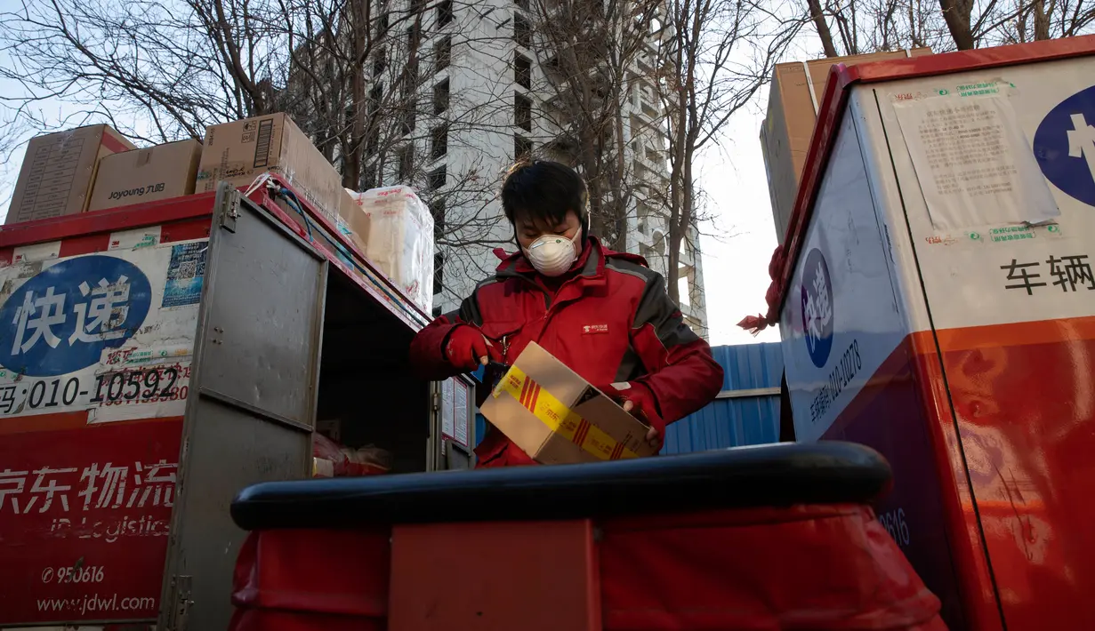 Kurir bersiap untuk melakukan pengiriman paket di pusat distribusi di Beijing, China, Selasa (18/2/2020). Hingga 19 Februari 2020, tercatat 2.118 orang meninggal dunia akibat virus corona atau COVID-19 di China. (AP Photo/Ng Han Guan)