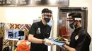 Pramusaji menggunakan pelindung wajah, masker dan sarung tangan saat melayani pelanggan di The Atjeh Connection Coffee and Resto, Jakarta, Senin (8/6/2020). Tempat ini siap menerapkan protokol kesehatan dalam menerapkan tatanan kehidupan baru atau ‘new normal’. (Liputan6.com/Faizal Fanani)