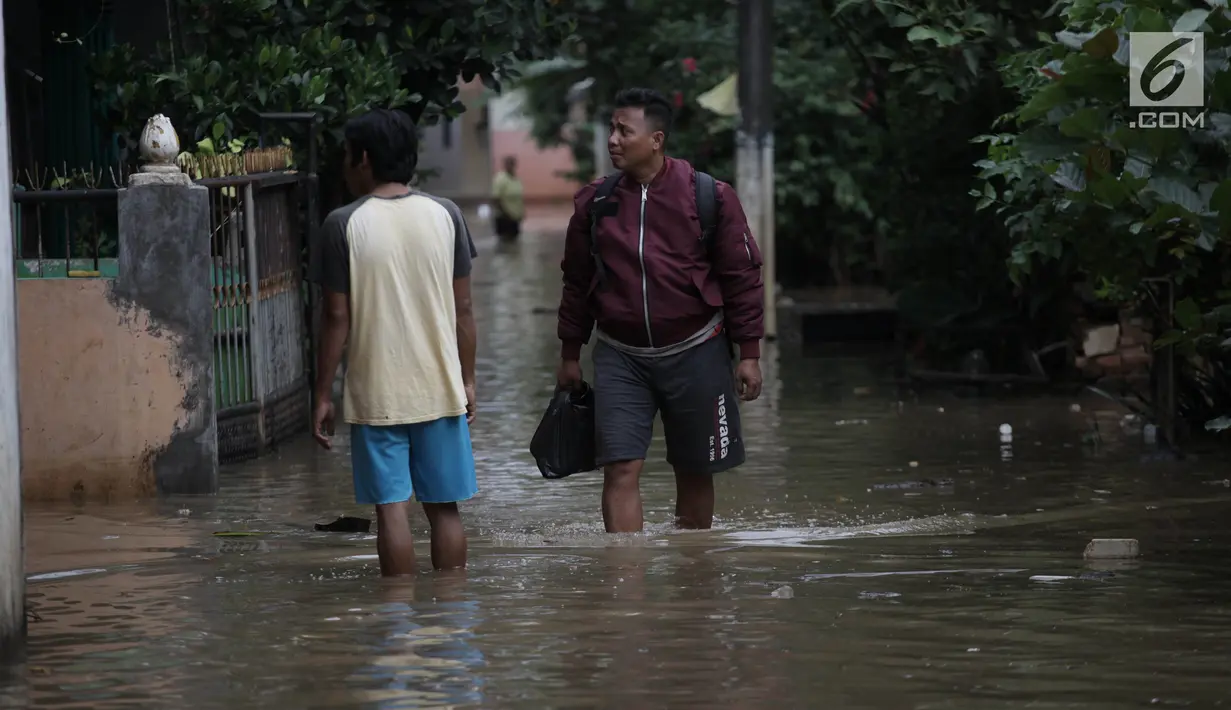 Warga beraktivitas saat banjir merendam kawasan Cipinang Melayu, Jakarta Timur, Senin (5/2). Akibat intensitas hujan yang cukup tinggi, permukiman di wilayah Cipinang Melayu tergenang air setinggi 30-40 cm. (Liputan6.com/Arya Manggala)