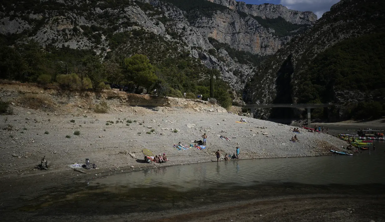 Orang-orang mandi di tepi pengeringan Verdon Gorge, Prancis selatan (9/8/2022). Secara keseluruhan, bagian selatan Prancis memperkirakan suhu siang hari hingga 40 derajat Celcius hingga tidak akan turun pada malam hari di bawah 20 derajat celcius. (AP Photo/Daniel Cole)