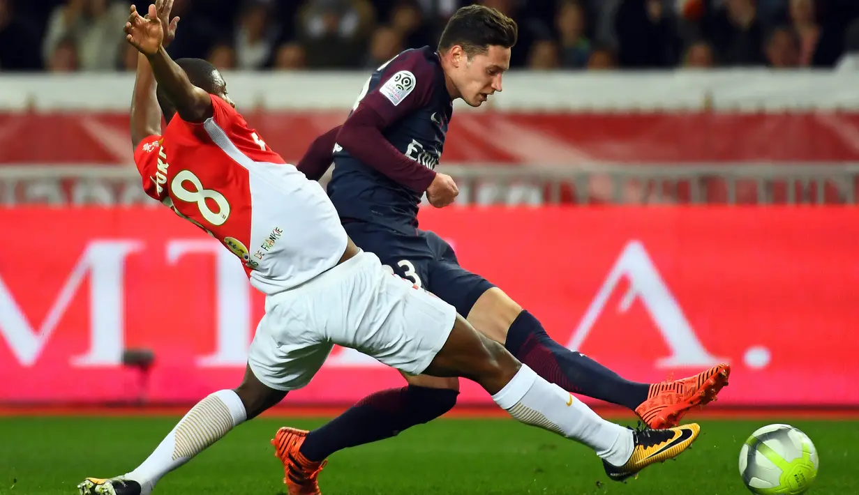 Aksi pemain AS Monaco, Almamy Toure (kiri) menahan laju pemain PSG, Julian Draxler pada lanjutan Ligue 1 di Louis II stadium, Monaco, (26/11/2017). PSG menang 2-1. (AFP/Anne-Christine Poujoulat)