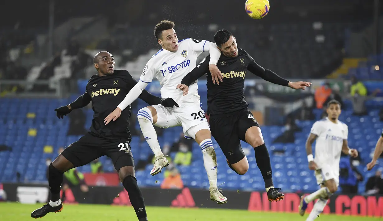 Penyerang Leeds United, Rodrigo (tengah) berusaha menyundul bola dari kawalan dua pemain West Ham, Angelo Ogbonna dan Fabian Balbuena pada pertandingan lanjutan Liga Inggris di stadion Elland Road, Inggris, Sabtu (12/12/2020). West Ham menang tipis atas Leeds United 2-1. (Gareth Copley, Pool via AP)