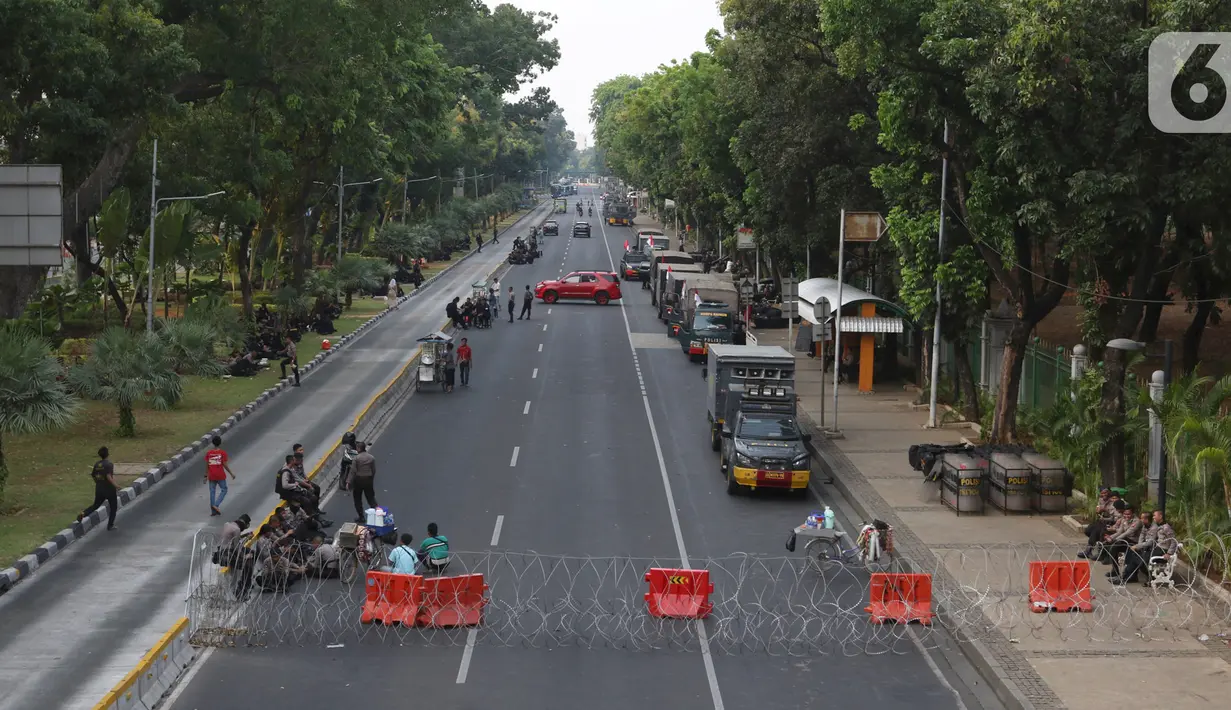 Polisi menjaga akses jalan menuju Istana Negara, Jakarta, Senin (14/10/2019). Hingga sore hari, polisi masih menutup jalan dikarenakan isu adanya demo mahasiswa yang akan berlangsung hari ini. (Liputan6.com/JohanTallo)