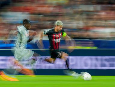 Pemain RB Salzburg Andreas Ulmer (kiri) berebut bola dengan pemain AC Milan Theo Hernandez pada pertandingan sepak bola Grup E Liga Champions di Stadion Salzburg, Salzburg, Austria, 6 September 2022. Pertandingan berakhir imbang 1-1. (AP Photo/Florian Schrotter)
