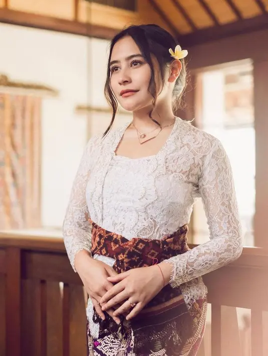 Prilly Latuconsina tampil memukau dalam balutan kebaya Bali lengan panjang berwarna putih. Kebaya tersebut dipadukan dengan kain jarik berwarna ungu. Tak lupa disempurnakan dengan sabuk khas Bali. (Instagram/prillylatuconsina).