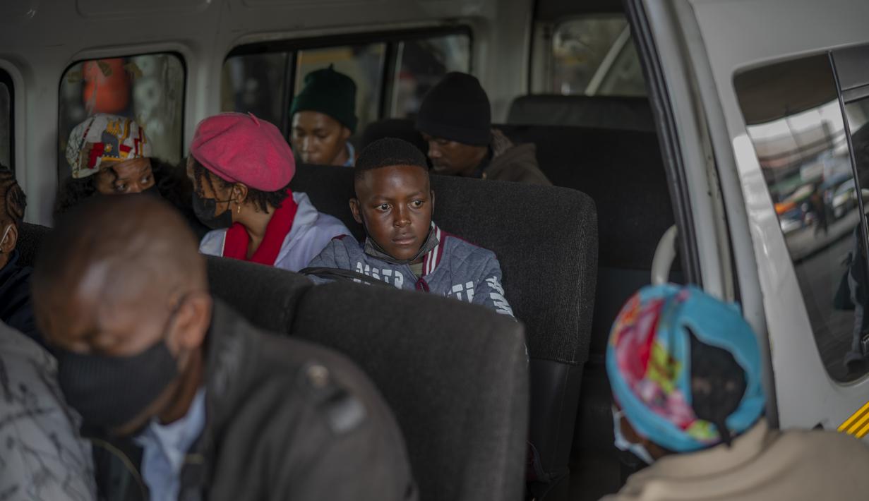Penumpang, beberapa memakai masker, menunggu taksi mereka meninggalkan pangkalan taksi Baragwanath di Soweto, Kamis (2/12/2021). Afrika Selatan mempercepat kampanye vaksinasi untuk memerangi lonjakan pesat kasus Covid-19 usai mendeteksi varian Omicron pekan lalu. (AP Photo/Jerome Delay)