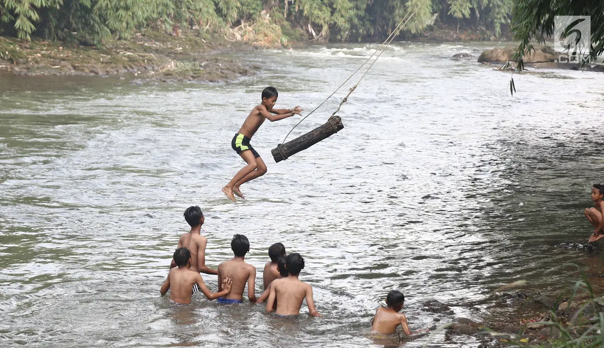 Anak-anak bermain air di aliran Sungai Ciliwung, Depok, Jawa Barat (30/5). Sungai Ciliwung kini menjadi tempat wisata alternative bagi masyarakat untuk bermain sekaligus menjaga kebersihan lingkungan. (Liputan6.com/Herman Zakharia)