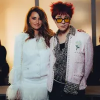 G-Dragon tampil nyentrik dalam balutan jaket tweed berwarna pink dengan aksen mutiara, kemeja ruffle bermotif dan celana hitam yang memberikan keseimbangan sempurna pada keseluruhan tampilan. Penampilannya kian stand out dengan rambut messy berwarna merah menyala. [Dok/Chanel].