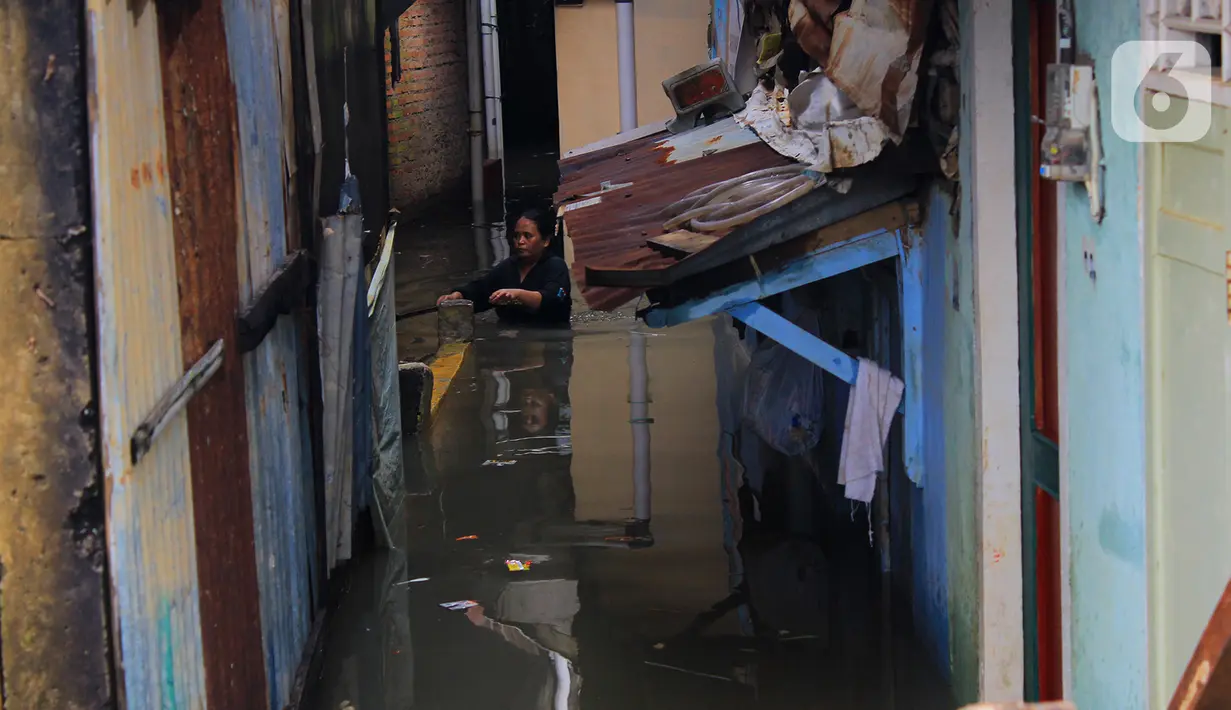 Aktivitas warga di tengah banjir yang merendam kawasan Kampung Melayu Kecil, Bukit Duri, Jakarta, Selasa (25/2/2020). Banjir tersebut akibat luapan sungai Ciliwung. (merdeka.com/magang/ Muhammad Fayyadh)