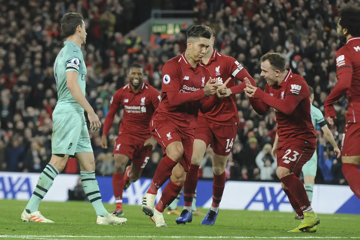 Para pemain Liverpool merayakan gol yang dicetak Roberto Firmino ke gawang Arsenal pada laga Premier League di Stadion Anfield, Liverpool, Sabtu (29/12). Liverpool menang 5-1 atas Arsenal. (AP/Rui Veira)
