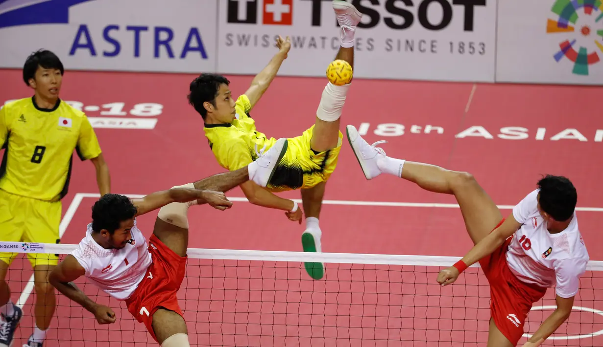 Pemain takraw Indonesia, Saiful Rijal dan Rizky Abdul Rahan Pago menahan tendangan Yuki Sato saat mengahadapi Jepang di final Asian Games 2018 di Palembang, Sabtu (1/9). Indonesia menang dengan skor (15-21, 21-14 dan 21-16). (AP Photo/Vincent Thian)