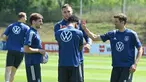 Pemain Jerman Thomas Mueller (kanan) bercanda dengan rekan setimnya saat sesi latihan di pusat olahraga BVSC, Budapest, Hungaria, 13 Juni 2022. Jerman akan menghadapi Italia pada pertandingan sepak bola UEFA Nations League. (Attila KISBENEDEK/AFP)