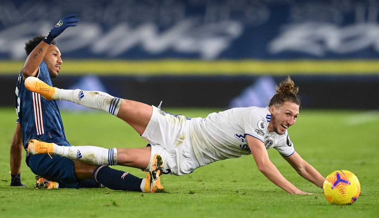 Bek Leeds United, Luke Ayling (kanan), terjatuh saat berebut bola dengan striker Arsenal, Pierre Emerick Aubameyang, dalam laga lanjutan Liga Inggris pekan ke-9 di Elland Road Stadium, Leeds, Minggu (22/11/2020). Leeds United bermain imbang 0-0 dengan Arsenal. (AFP/Michael Regan/Pool)