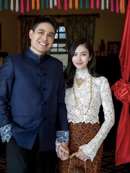 Nong Poy tampak begitu memukau dengan gaya semi etnik. Ia padukan atasan lace serta kain tradisional menyerupai motif batik. Sedangkan sang suami juga kenakan atasan beskap dengan sentuhan kain etnik. [Foto: Instagram/ Nong Poy]